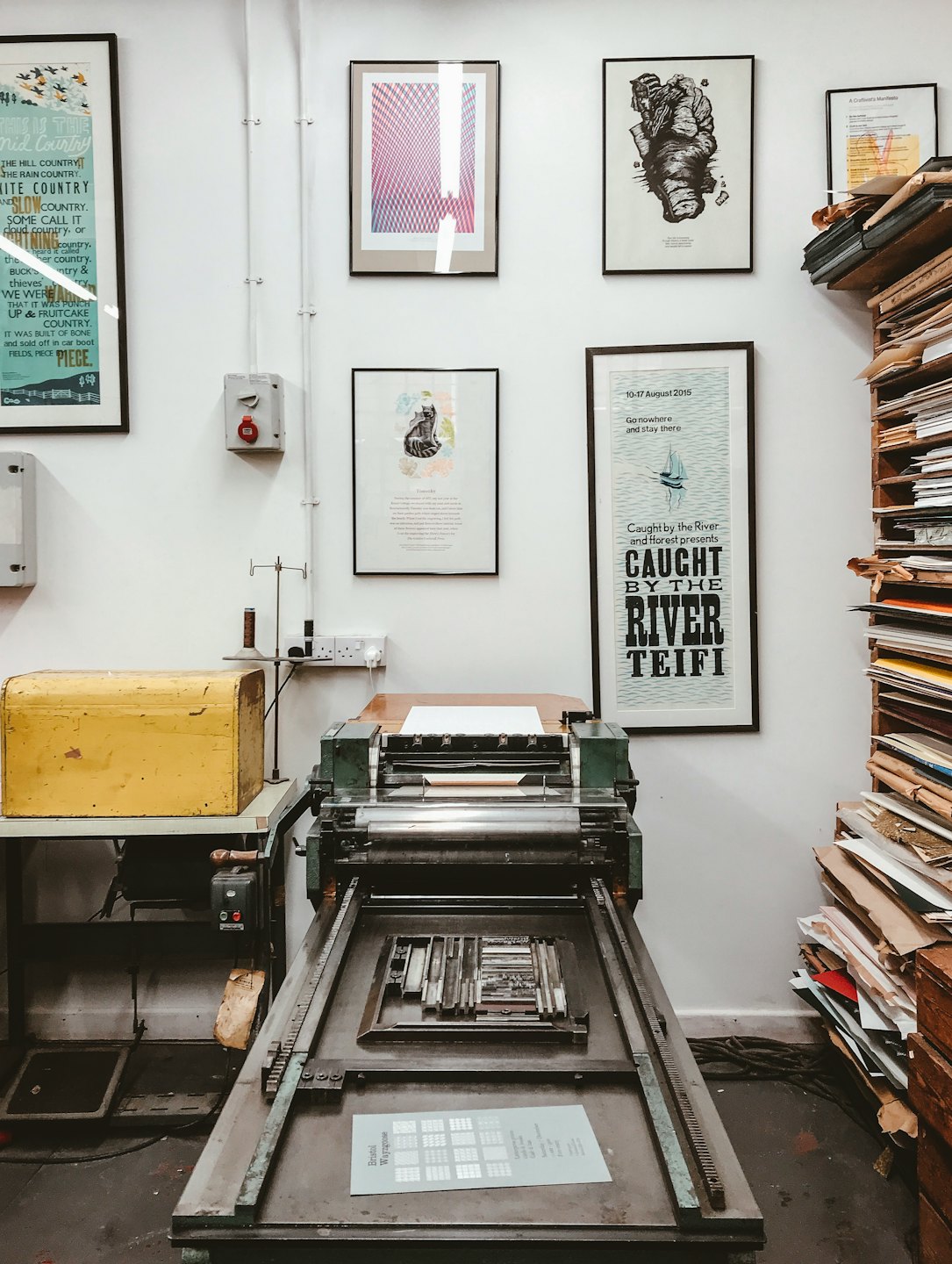 Eine große, alte Buchdruckmaschine mit gesetzten Lettern zum Drucken.