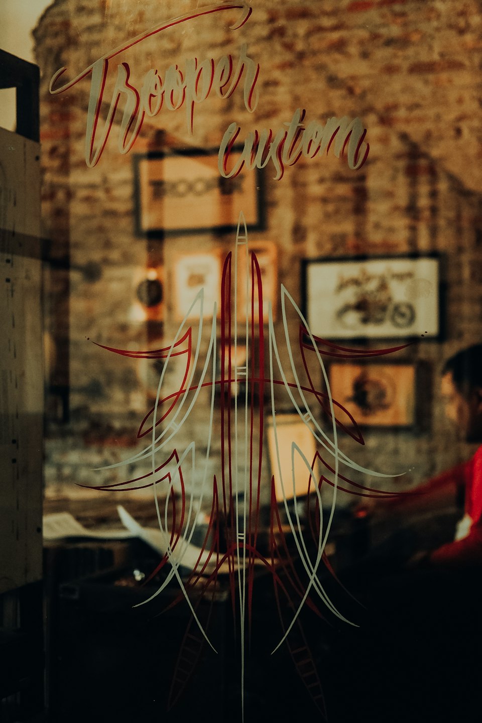Individuelle handgeschriebene Schriftzüge und Pinstriping-Kunst auf einem Schaufenster.