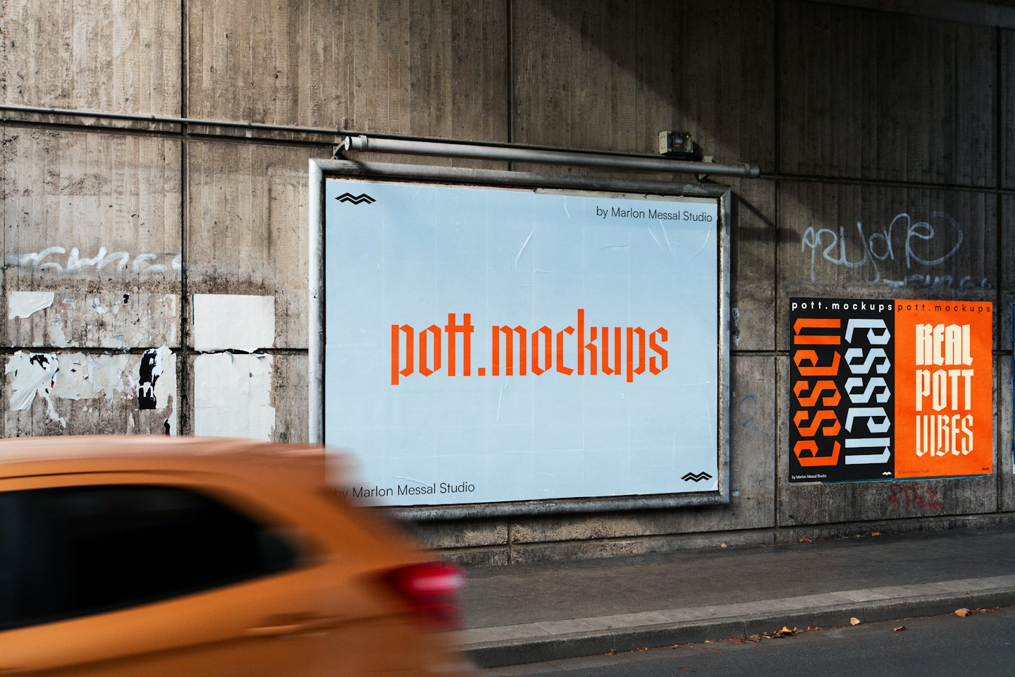Eine große Werbetafel und Plakate sind an einer Betonwand angebracht.